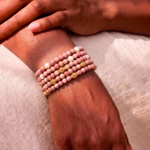 Rosa Rhodonit-Armbänder mit Perlen und goldenen Filigrankugeln am Handgelenk